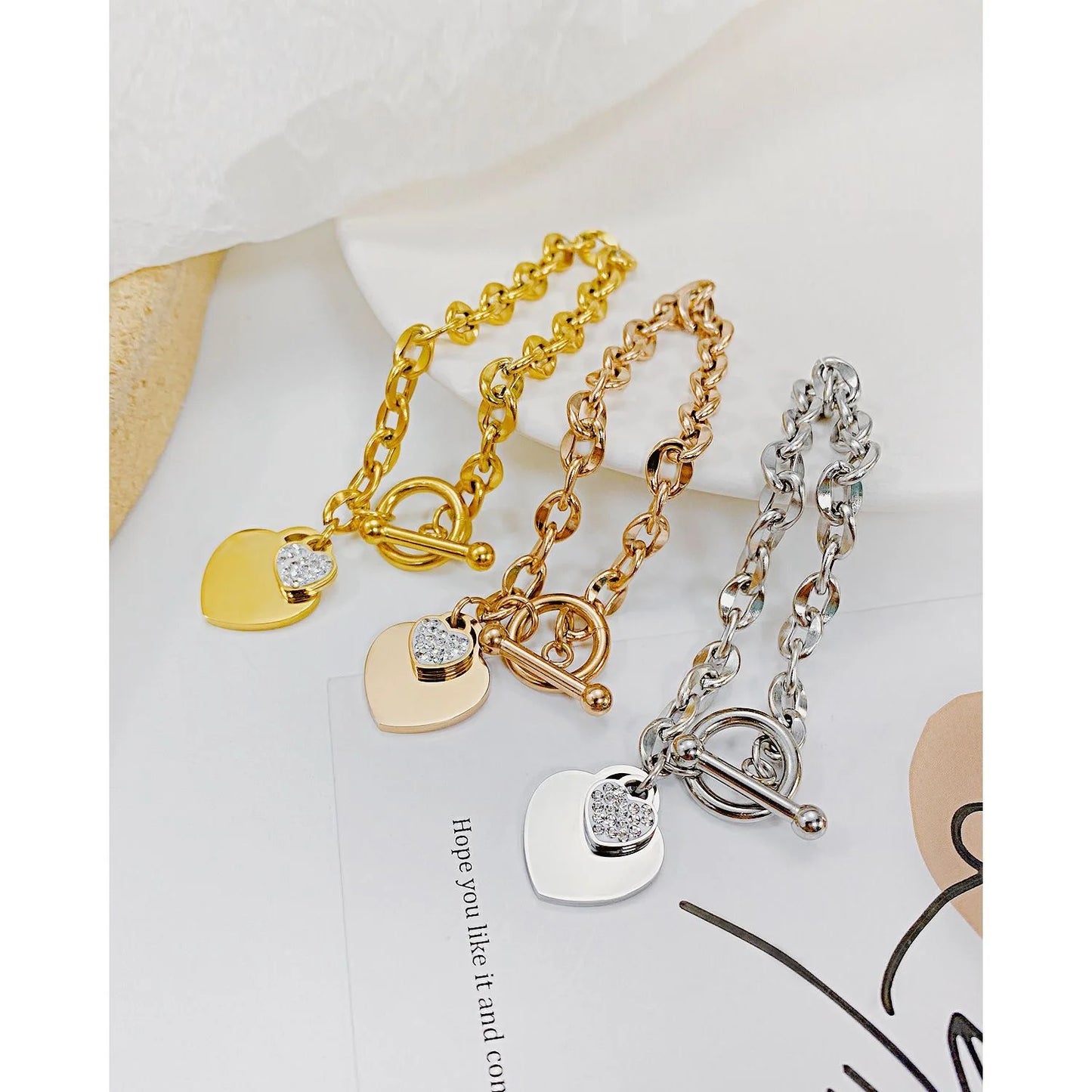 Explore our collection of waterproof geometric heart pendant bracelets and bangles for women and girls. Crafted from 316L stainless steel and plated with gold, these accessories are designed to retain their shine and shape over time